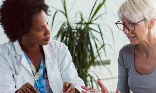 Primary Care Nurse Practitioner Consulting with Adult Female Patient